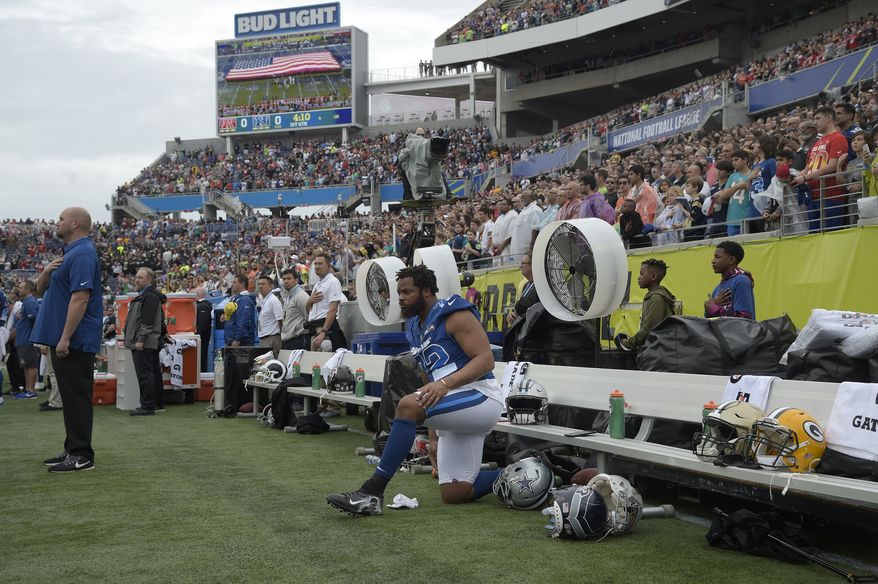 NFC defensive end Michael Bennett (72), of the Seattle Seahawks, kneels in front of the bench during the singing of the national anthem before the NFL Pro Bowl football game Sunday, Jan. 28, 2018, in Orlando, Fla. The AFC won 24-23. (AP Photo/Phelan M. Ebenhack)