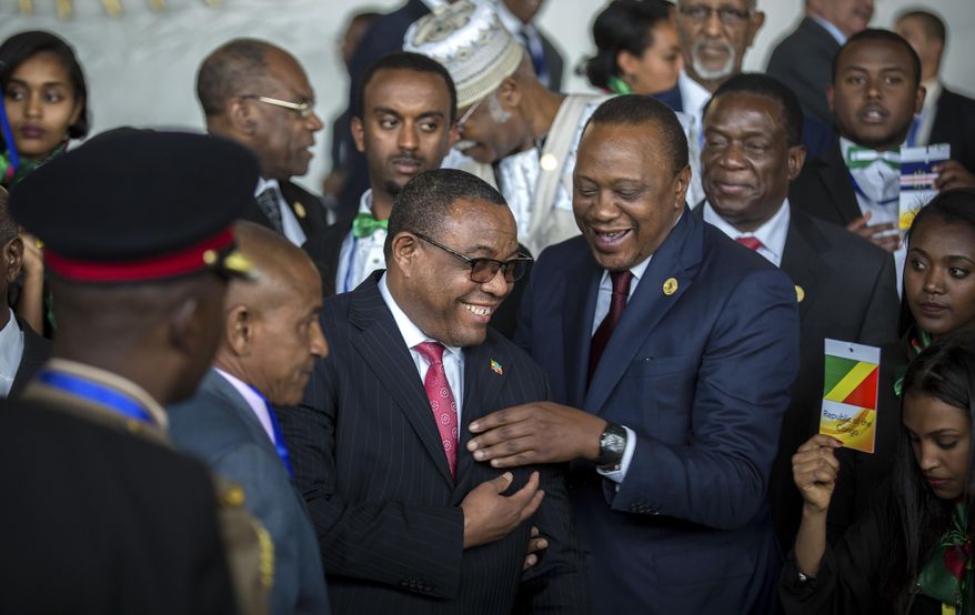 Kenya's President Uhuru Kenyatta, center-right, laughs with Ethiopia's Prime Minister Hailemariam Desalegn, center-left, at the opening ceremony of the African Union summit in Addis Ababa, Ethiopia Sunday, Jan. 28, 2018. The leaders of the United Nations and the African Union urged stronger international cooperation at the opening Sunday of the African Union summit in the Ethiopian capital, Addis Ababa. (AP Photo/Mulugeta Ayene)