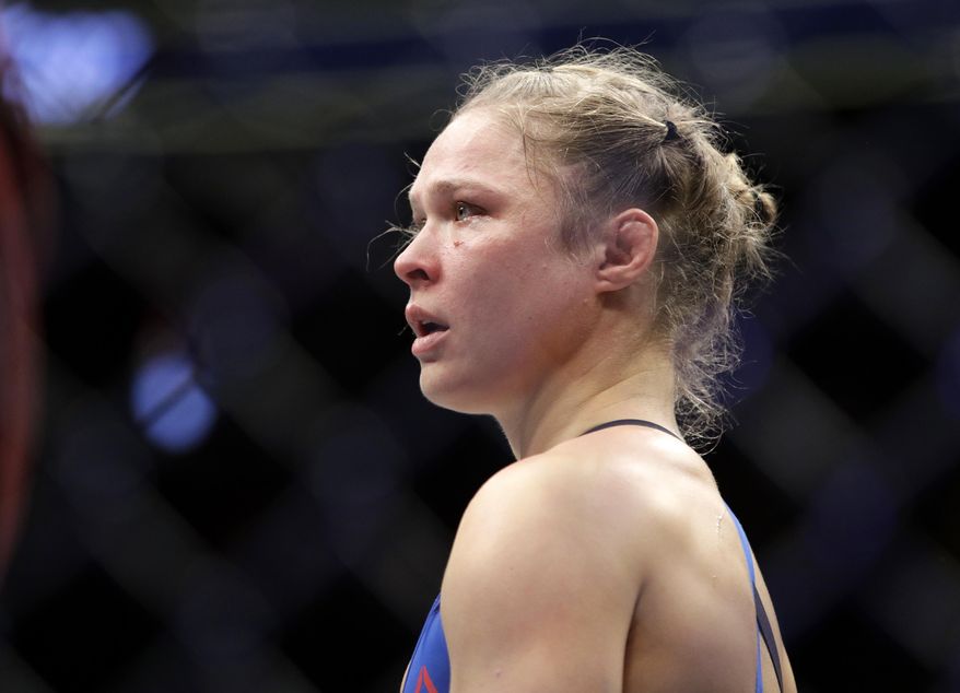 In this Dec. 30, 2016, file photo, Ronda Rousey stands in the cage after Amanda Nunes forced a stoppage in the first round of their women&#39;s bantamweight championship mixed martial arts bout at UFC 207 in Las Vegas. (AP Photo/John Locher) ** FILE **
