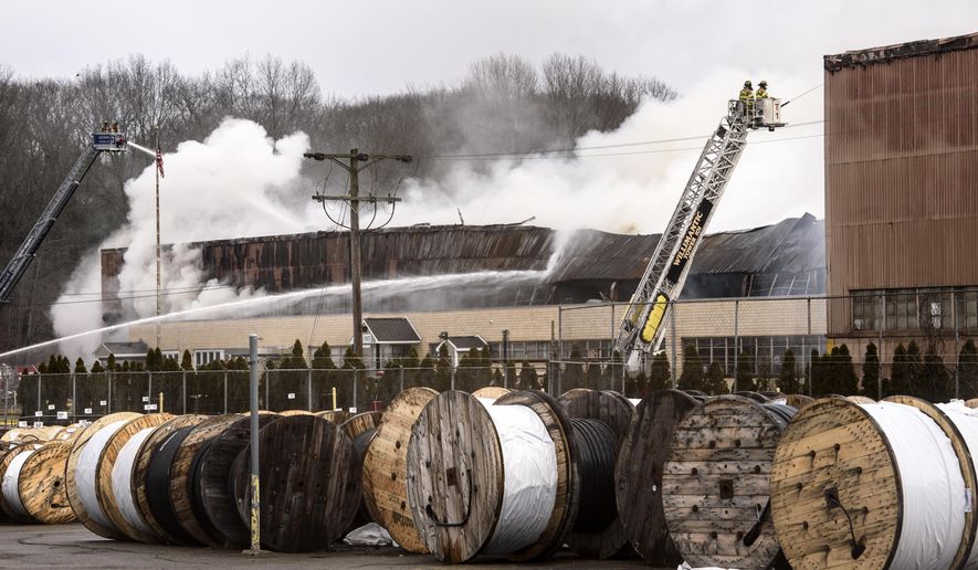 Fire officials work a fire at a Willimantic Waste Paper Co., Inc. building at 1590 West Main Street Sunday, Jan. 28, 2018, in Willimantic, Conn. Fire officials say several departments are on the scene east of Hartford. (Mark Mirko/Hartford Courant via AP)