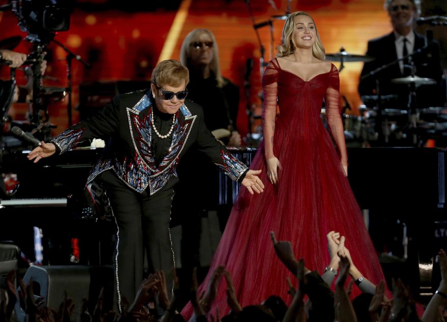 Elton John, left, and Miley Cyrus appear after a performance of "Tiny Dancer" at the 60th annual Grammy Awards at Madison Square Garden on Sunday, Jan. 28, 2018, in New York. (Photo by Matt Sayles/Invision/AP)