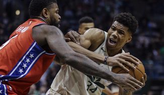 Milwaukee Bucks&#39; Giannis Antetokounmpo, right, is tied up by Philadelphia 76ers&#39; Amir Johnson during the second half of an NBA basketball game Monday, Jan. 29, 2018, in Milwaukee. (AP Photo/Tom Lynn)