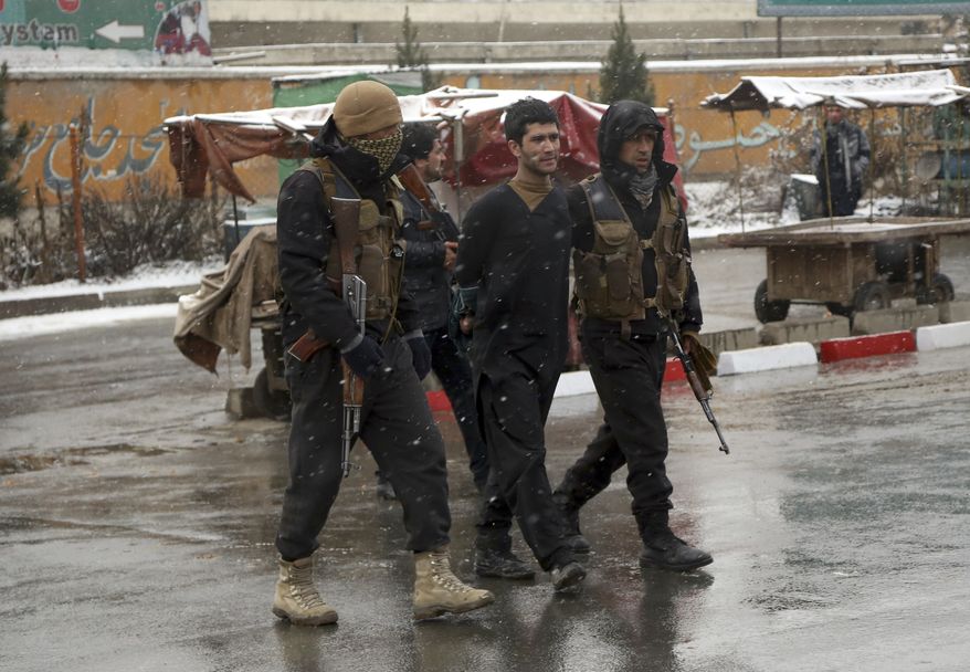Afghan security personnel detain a suspect at the site of an attack on the Marshal Fahim military academy in Kabul, Afghanistan, Monday, Jan. 29, 2018. Militants attacked an Afghan army unit guarding the military academy on Monday, officials said. Hours later, the Islamic State group claimed responsibility for the assault. (AP Photo/Rahmat Gul)
