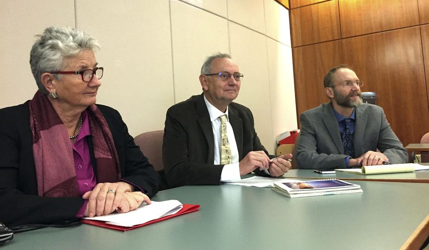Former Santa Fe Mayor David Coss, middle, announces a lawsuit on Monday, Jan. 29, 2018, in Santa Fe, N.M., accusing the state of New Mexico of unlawfully denying driver's authorization cards to some residents under a system adopted in 2016 to meet federal REAL ID Act requirements. State Sen. Liz Stefanics, left, and New Mexico ACLU Executive Director Peter Simonson sit in. (AP Photo/Morgan Lee)