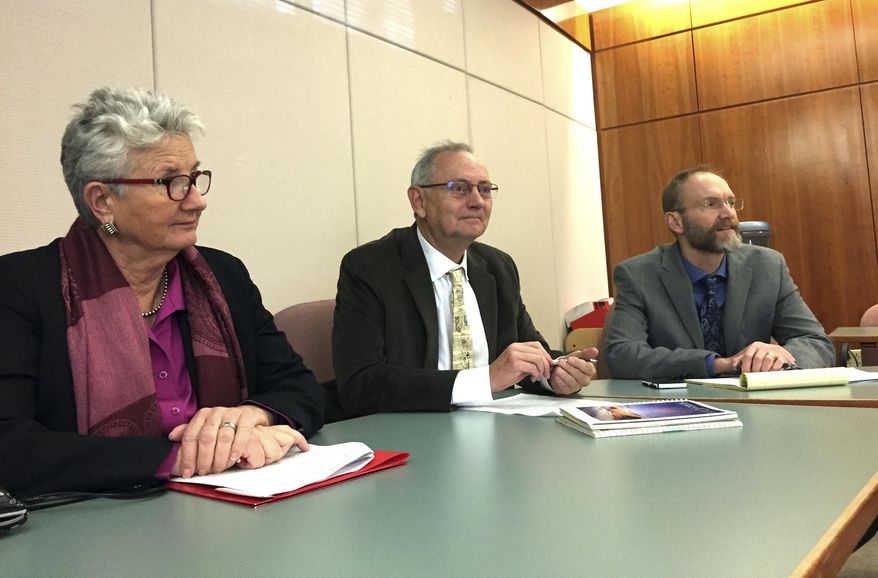 Former Santa Fe Mayor David Coss, middle, announces a lawsuit on Monday, Jan. 29, 2018, in Santa Fe, N.M., accusing the state of New Mexico of unlawfully denying driver's authorization cards to some residents under a system adopted in 2016 to meet federal REAL ID Act requirements. State Sen. Liz Stefanics, left, and New Mexico ACLU Executive Director Peter Simonson sit in. (AP Photo/Morgan Lee)