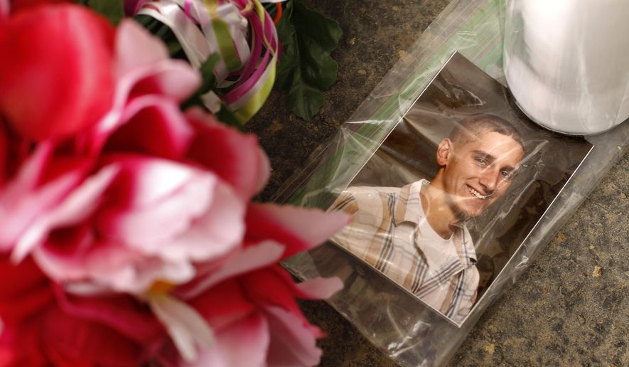 A photo of victim William Porterfield sits at a memorial near Ed's Car Wash after a deadly shooting Monday, Jan. 29, 2018, in Saltlick Township, Pa. State police said Timothy Smith opened fire early Sunday morning at the car wash, killing several. (AP Photo/Gene J. Puskar)
