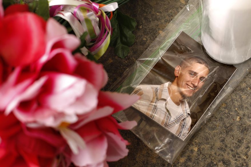A photo of victim William Porterfield sits at a memorial near Ed's Car Wash after a deadly shooting Monday, Jan. 29, 2018, in Saltlick Township, Pa. State police said Timothy Smith opened fire early Sunday morning at the car wash, killing several. (AP Photo/Gene J. Puskar)
