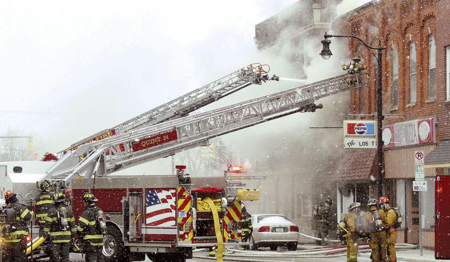 Firemen fight a raging fire that broke out in downtown Butler, Ind., around 11:30 a.m. Tuesday, Jan. 30, 2018. A building in the 100 block of South Broadway was burning out of control into the early afternoon. WANE-TV quotes Butler fire officials as saying that at least six people have been taken to hospitals for treatment of injuries suffered in the blaze. They say two police officers who responded to the scene have been treated for smoke inhalation. (Dave Kurtz/Auburn Star via AP)