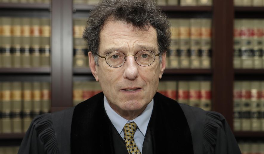 FILE - This Jan. 11, 2018 file photo shows judge Dan Polster in his office in Cleveland. Polster has called the opioid addiction epidemic “100 percent man-made” and asserted that other branches of government have “punted” on solving it. Polster has made clear that he wants to use the cases before him as a way to forge a solution to the opioid crisis _ not just a legal resolution. (AP Photo/Tony Dejak, file)
