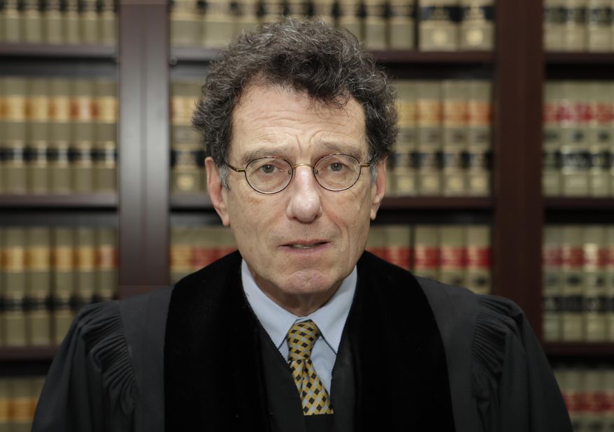 FILE - This Jan. 11, 2018 file photo shows judge Dan Polster in his office in Cleveland. Polster has called the opioid addiction epidemic “100 percent man-made” and asserted that other branches of government have “punted” on solving it. Polster has made clear that he wants to use the cases before him as a way to forge a solution to the opioid crisis _ not just a legal resolution. (AP Photo/Tony Dejak, file)