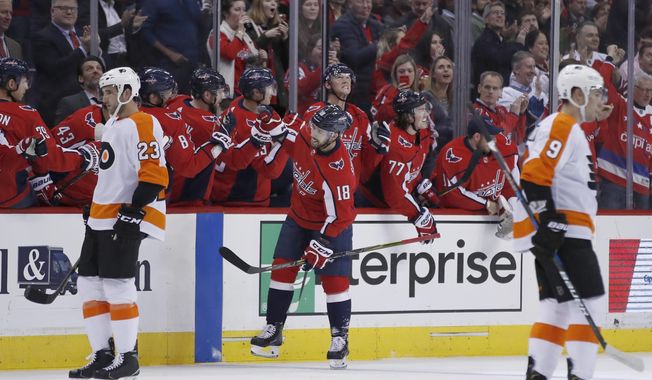 Washington Capitals center Chandler Stephenson (18) celebrates his goal with his teammates, with Philadelphia Flyers defensemen Brandon Manning (23) and Ivan Provorov (9), from Russia, nearby during the second period of an NHL hockey game Wednesday, Jan. 31, 2018, in Washington. (AP Photo/Alex Brandon)