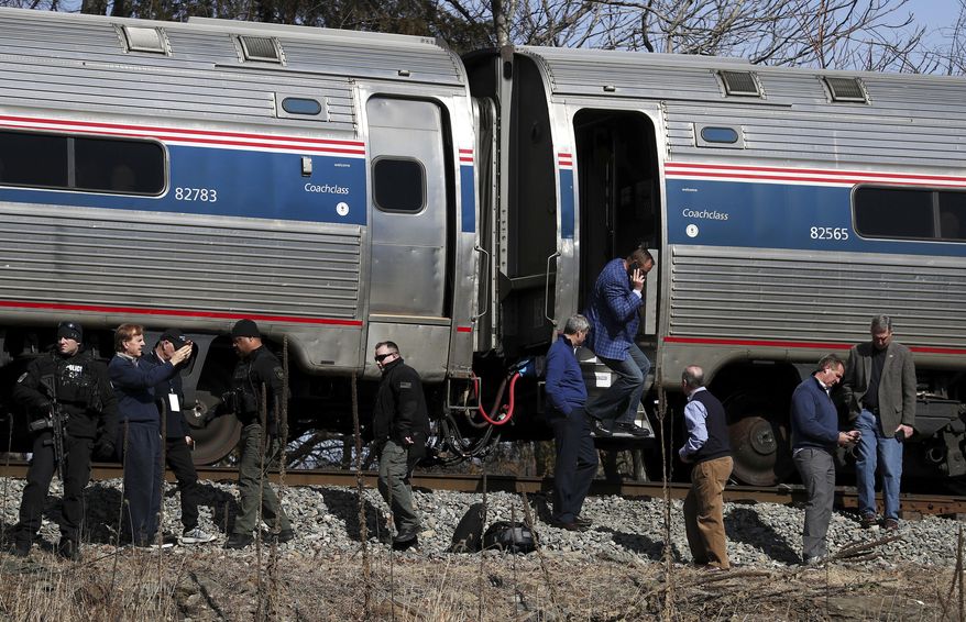 Passengers watch as emergency personnel operate work at the scene of a train crash involving a garbage truck in Crozet, Va., on Wednesday, Jan. 31, 2018. An Amtrak passenger train carrying dozens of GOP lawmakers to a Republican retreat in West Virginia struck a garbage truck south of Charlottesville, Va. No lawmakers were believed injured, but it at least one person in the truck was said to be seriously injured. (Zack Wajsgrasu/The Daily Progress via AP)