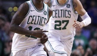 Boston Celtics guard Terry Rozier (12) smiles as he heads up court with forward Daniel Theis, after completing a triple-double with a pass to Theis for a slam dunk, during the second half of an NBA basketball game in Boston, Wednesday, Jan. 31, 2018. Rozier filled in nicely for the injured Kyrie Irving, logging his first career triple-double with 17 points, 11 rebounds and 10 assists in his first NBA start. The Celtics won 103-73. (AP Photo/Charles Krupa)
