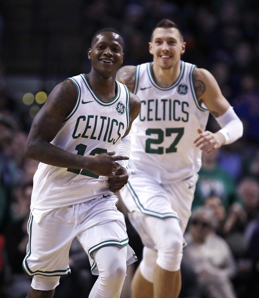 Boston Celtics guard Terry Rozier (12) smiles as he heads up court with forward Daniel Theis, after completing a triple-double with a pass to Theis for a slam dunk, during the second half of an NBA basketball game in Boston, Wednesday, Jan. 31, 2018. Rozier filled in nicely for the injured Kyrie Irving, logging his first career triple-double with 17 points, 11 rebounds and 10 assists in his first NBA start. The Celtics won 103-73. (AP Photo/Charles Krupa)