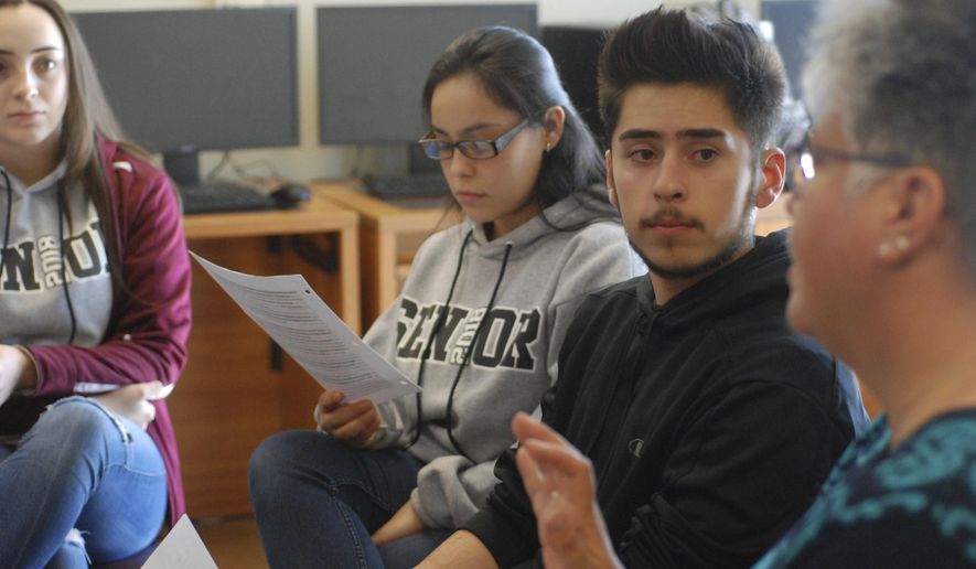 In this Jan. 18, 2018, photo, high school seniors John King, second from right, Ashley Zapata, second from left, and Felicity Sealy, left, listen as English and college-preparation teacher Rhonda Gardner leads a discussion about how to adjust to the academic, financial and social pressures of collegiate life on Thursday, Jan. 18, 2018, in Santa Fe, N.M. (AP Photo/Morgan Lee)