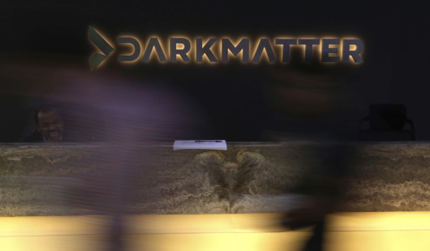 In this Tuesday, Jan. 30, 2018 photo, taken with a long exposure, employees walk into offices of the cybersecurity firm DarkMatter, in Abu Dhabi, United Arab Emirates. DarkMatter, a growing cybersecurity company that’s recruited Western intelligence analysts, is slowly stepping out of the shadows amid activist concerns about its power. CEO Faisal al-Bannai says DarkMatter takes part in no hacking but acknowledges the firm’s close business ties to the Emirati government, as well as hiring former CIA and National Security Agency analysts. (AP Photo/Jon Gambrell)