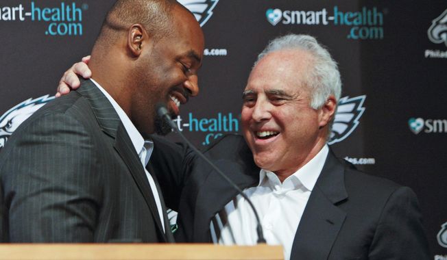 FILE - In this July 29, 2013, file photo, six-time Pro Bowl quarterback Donovan McNabb, left, and Philadelphia Eagles owner Jeffrey Lurie embrace following a news conference in Philadelphia, where it was announced that McNabb was to officially retire as a member of the Eagles. McNabb played 11 of his 13 seasons with the Eagles, leading them to eight playoff appearances, five NFC East titles, five conference championship games and one Super Bowl loss. Lurie grew up a passionate Boston sports fan. He even tried to buy the Patriots in 1993 but was outbid by Robert Kraft. So the former movie producer paid $195 million for the Eagles in 1994. Lurie vowed to win multiple championships for a city that hasn&#x27;t celebrated an NFL title since 1960.He&#x27;s still waiting for No. 1. Nothing else matters this week. (AP Photo/ Joseph Kaczmarek, File)
