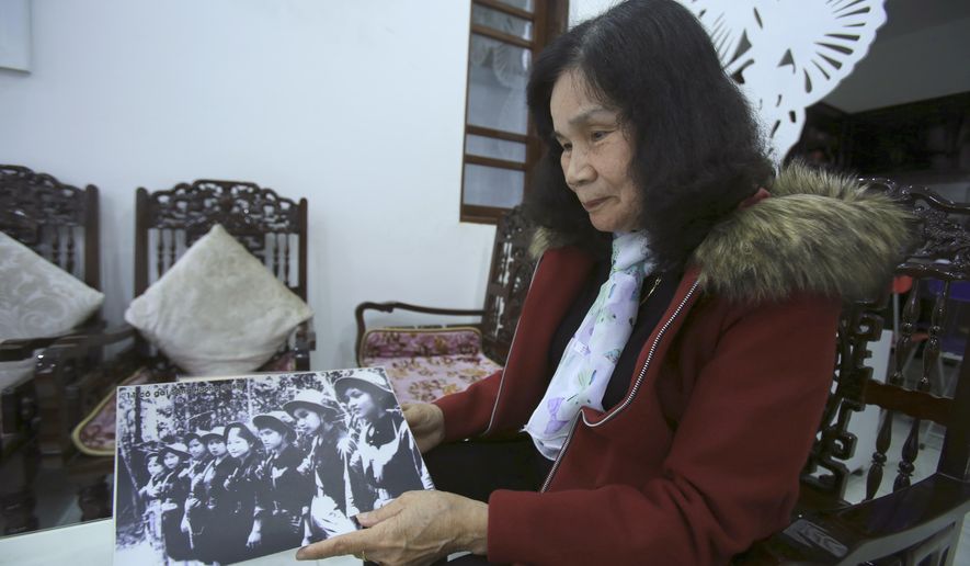 In this Tuesday, Jan. 30, 2018, photo, veteran spy Hoang Thi No holds up a photo of all-female "Perfume River squad" in Hue, Vietnam. Vietnam on Wednesday, Jan. 31, 2018, commemorated the 50th anniversary of the Tet Offensive, a tactical setback for the northern troops but a strategic turning point of the Vietnam War. (AP Photo/Hau Dinh)