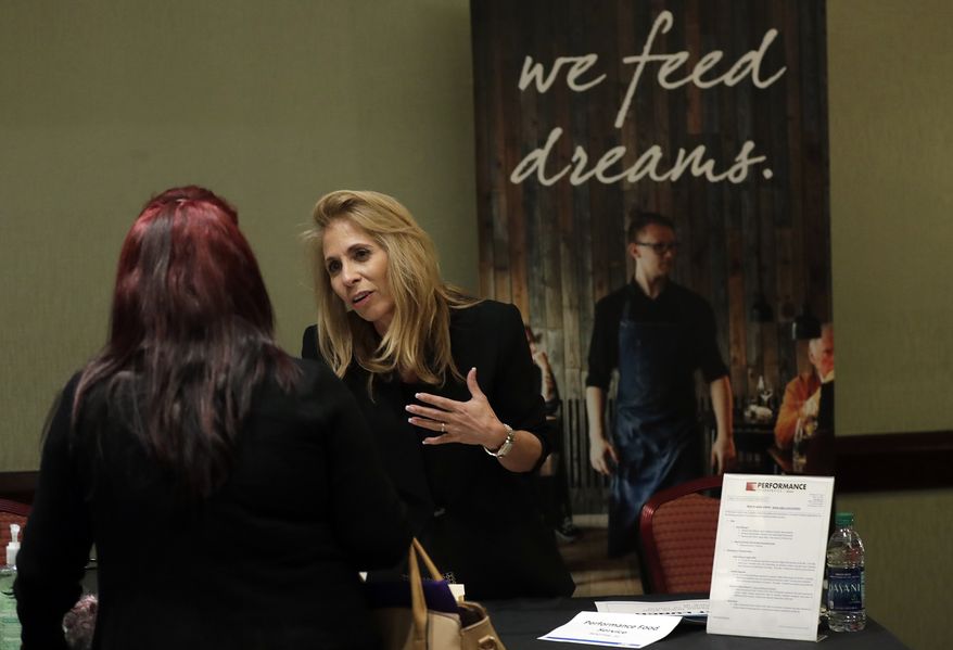 In this Tuesday, Jan. 30, 2018, photo, Grace Ochoa, of Performance Food Service, right, talks with a job applicant at a JobNewsUSA job fair in Miami Lakes, Fla. On Friday, Feb. 2, the U.S. government issues the January jobs report. (AP Photo/Lynne Sladky)
