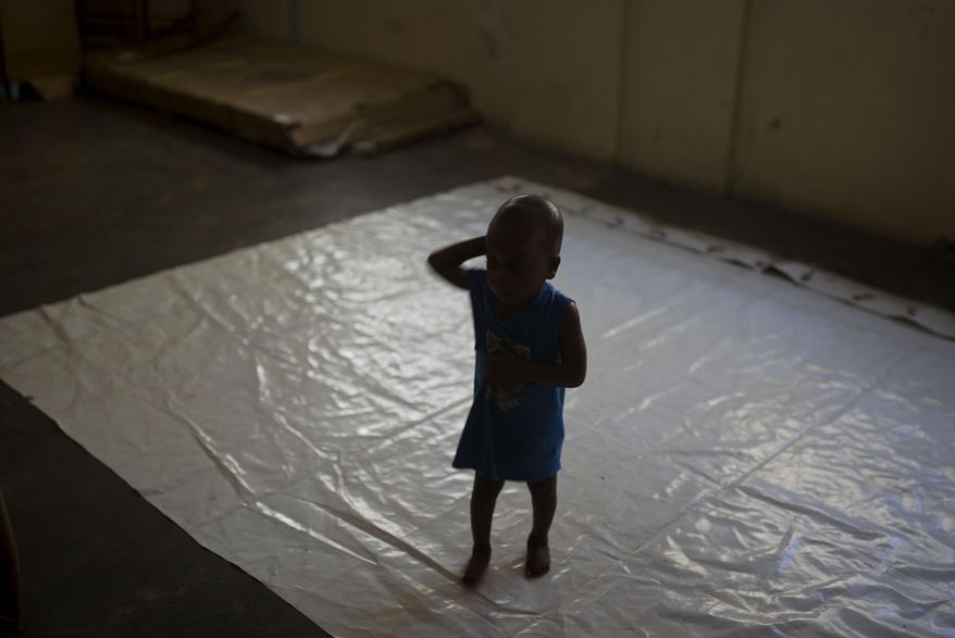 A boy stands on a tarp at the Foyer Notre Dame de la Nativite orphanage on the outskirts of Port-au-Prince, Haiti, Friday, Feb. 2, 2018. The State Department is being urged by a group of U.S. senators to pressure the Haitian government into closing the orphanage where several children being adopted by U.S. families have been victims of alleged sexual abuse. (AP Photo/Dieu Nalio Chery)