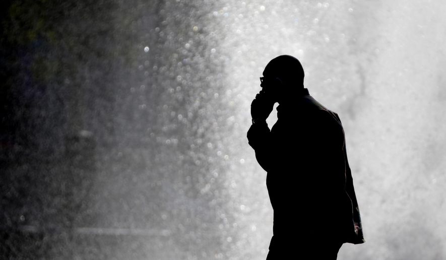 FILE - In this Thursday, Oct. 11, 2012 file photo, a pedestrian talking on a cellphone is silhouetted in front of a fountain at John F. Kennedy Plaza, also known as Love Park in Philadelphia. Released on Friday, Feb. 2, 2018, two government studies that bombarded rats and mice with cellphone radiation found a weak link to some heart tumors, but the research does not provide any clear answers about the safety of the devices that seem like extensions of our bodies. (AP Photo/Matt Rourke)