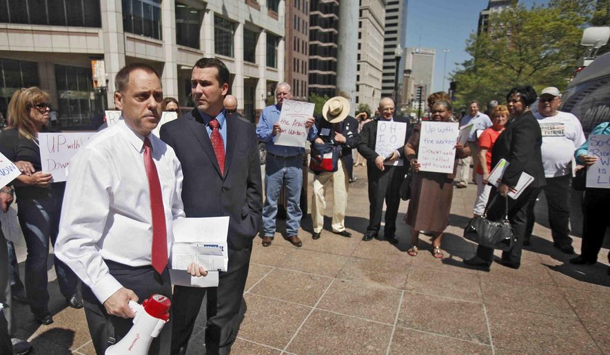 FILE-This Wednesday, May 1, 2013 file photo shows Ohio AFL-CIO President Tim Burga, left, and Tom Enright, a Journeyman Electrician for Romanoff Electric working at Jeep Plant in Toledo, protesting proposed Right to Work Legislation in Columbus, Ohio. A handful of states in the Midwest now surrounded by neighbors with so-called right-to-work laws are facing new efforts aimed at changing their labor laws. In Ohio, a pair of Republican lawmakers wants to put the issue before voters in two years. Missouri's new right-to-work law will go to a statewide referendum in November. (Tom Dodge, The Columbus Dispatch via AP, File)