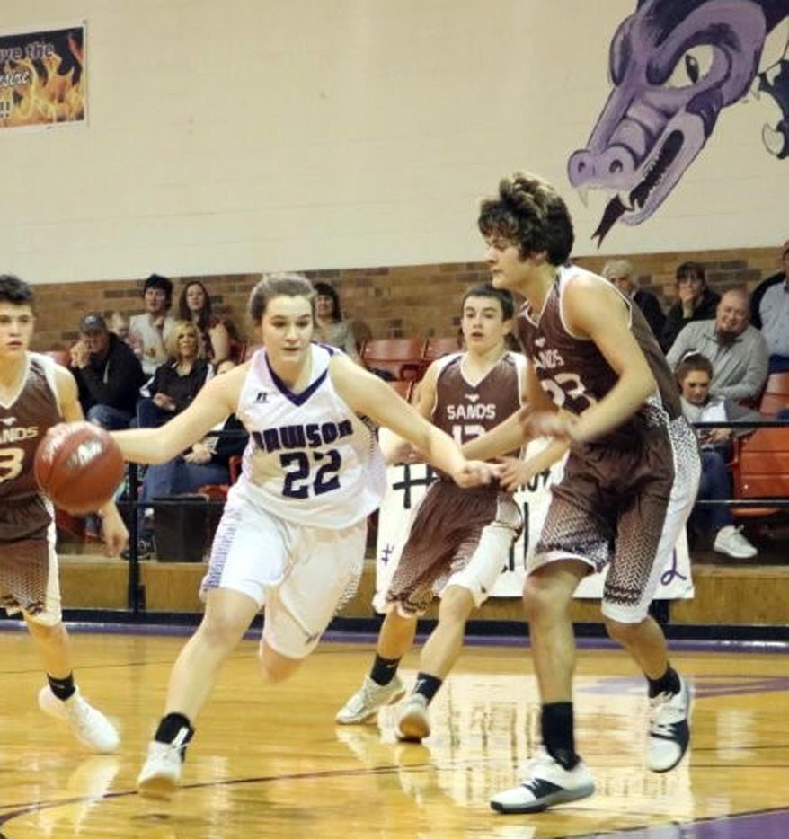 In this Friday, Jan. 26, 2018 photo, Dawson’s Murissa Horton (22) dribbles through several Sands defenders during a high school basketball game in Welch, Texas. At the smallest high school in Texas, injuries and dwindling enrollment forced the Dawson Dragons to consolidate the girls and boys basketball teams. The co-ed squad is playing a boys schedule. (AP Photo/Kristi Rieken)