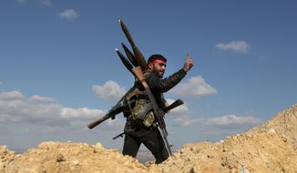 A pro-Turkey Syrian fighter waves on Bursayah hill, which separates the Kurdish-held enclave of Afrin from the Turkey-controlled town of Azaz, Syria, Sunday, Jan. 28, 2018. Turkish troops and allied Syrian fighters captured the strategic hill in northwestern Syria after intense fighting on Sunday as their offensive to root out Kurdish fighters enters its second week, according to Turkish officials. (AP Photo)