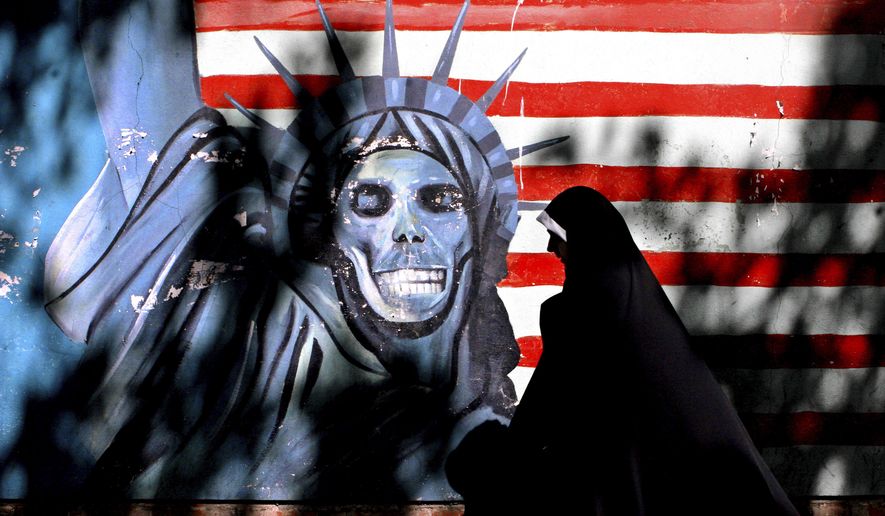 FILE - In this Sept. 25, 2007 file photo, an Iranian woman walks past graffiti art characterizing the U.S. Statue of Liberty, painted on the wall of the former U.S. Embassy in Tehran, Iran. An Iranian-American businessman and his father, who are serving 10-year prison sentences in Iran over their ties to the U.S., have lost a court appeal, a lawyer said Monday, Aug. 28, 2017. Siamak Namazi and his 81-year-old father Baquer, who are among several dual nationals detained in Iran, learned Sunday that the Tehran Appeals Court denied their appeal, Washington-based lawyer Jared Genser said. (AP Photo/Vahid Salemi, File)