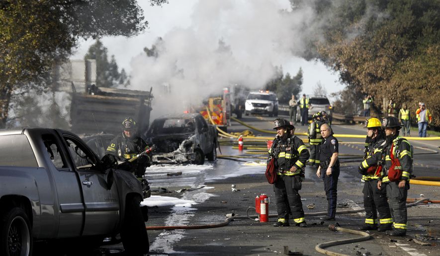First responders work at the scene of a multi-vehicle fire at Fountaingrove Parkway and Mendocino Avenue in Santa Rosa, on Monday, Feb. 5, 2018, after a dump truck plowed through a California intersection, in Santa Rosa, Calif., slamming into a number of other vehicles that caught fire and sent six people to hospitals, authorities said. No fatalities were immediately reported. (Beth Schlanker /The Press Democrat via AP)
