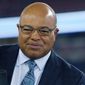FILE - In this Oct. 22, 2017 file photo, NFL sportscaster Mike Tirico sits on the sideline set before an NFL football game between the New England Patriots and the Atlanta Falcons in Foxborough, Mass. Tirico is replacing Bob Costas as host of NBC&#39;s prime-time Olympics coverage, which starts Thursday, Feb. 8, 2018, from South Korea. Costas was host for 11 Olympic games. (AP Photo/Bill Sikes, File)