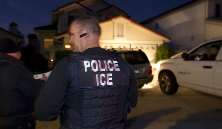 In this March 30, 2012 photo, an Immigration and Customs Enforcement (ICE) agent waits with other agents outside of the home of a suspect before dawn as part of a nationwide immigration sweep in San Diego. Federal officials say they arrested more than 3,100 immigrants convicted of serious crimes and fugitives in a six-day nationwide sweep. Officials at U.S. Immigration and Customs Enforcement say the sweep included every state and involved more than 1,900 of the agency&amp;#8217;s officers and agents.  (AP Photo/Gregory Bull)