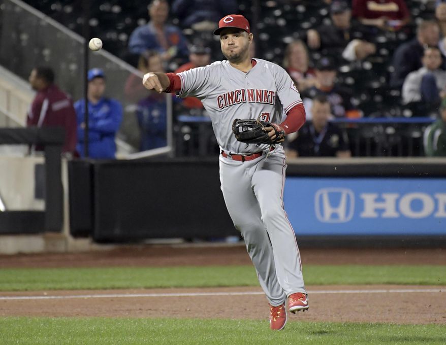 FILE - In this Sept. 7, 2017, file photo, Cincinnati Reds third baseman Eugenio Suarez throws out New York Mets' Kevin Plawecki during a baseball game in New York. The Reds won their salary arbitration case against Suarez, who gets a raise from $595,000 to $3.75 million rather than his request for $4.2 million. (AP Photo/Bill Kostroun, File)