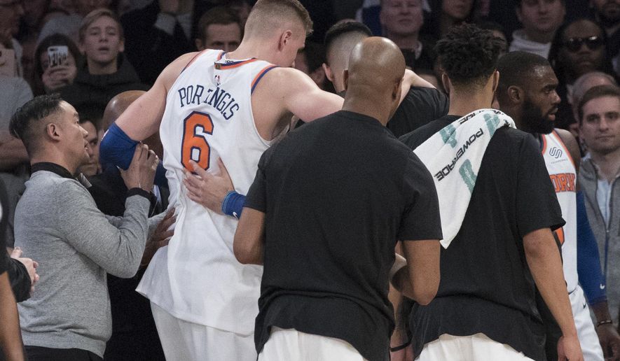 New York Knicks forward Kristaps Porzingis is helped off the court after being injured during the first half of the team's NBA basketball game against the Milwaukee Bucks, Tuesday, Feb. 6, 2018, at Madison Square Garden in New York. (AP Photo/Mary Altaffer)