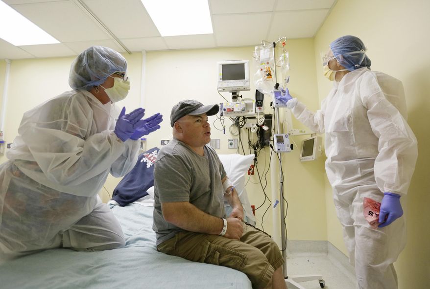 FILE - In this Monday, Nov. 13, 2017 file photo, Brian Madeux, starts to receive the first human gene editing therapy for Hunter syndrome, as his girlfriend Marcie Humphrey, left, applauds at the UCSF Benioff Children's Hospital in Oakland, Calif. At right is nurse practitioner Jacqueline Madden. Gene editing aims to permanently change someone's DNA to try to cure a disease. (AP Photo/Eric Risberg)
