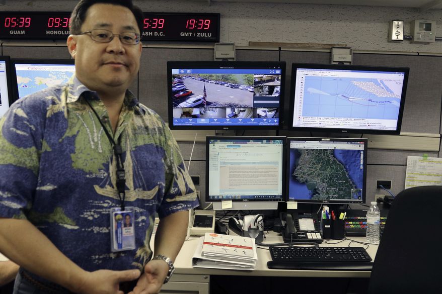 FILE - In this July 21, 2017 file photo, Jeffrey Wong, the Hawaii Emergency Management Agency's operations officer, shows computer screens monitoring hazards at the agency's headquarters in Honolulu. The photo originally accompanied an Associated Press story in July about Hawaii preparing for a missile threat from North Korea. Some online news organizations used the AP photo in their coverage of the Jan. 13, 2018 false missile alert in Hawaii, leading some people to believe Wong was the person who sent the false alert. The AP did not use the image in coverage of the false alert. Wong says he has received threats and harassment because of the use of the image online. (AP Photo/Jennifer Sinco Kelleher, File)