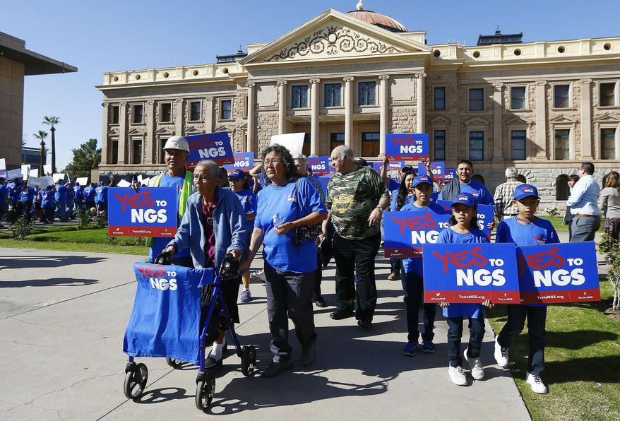 A coalition of groups march during a rally to build support for extending the life of the Navajo Generating Station power plant near the Arizona-Utah border, in front of the Arizona Capitol Tuesday, Feb. 6, 2018, in Phoenix. (AP Photo/Ross D. Franklin)