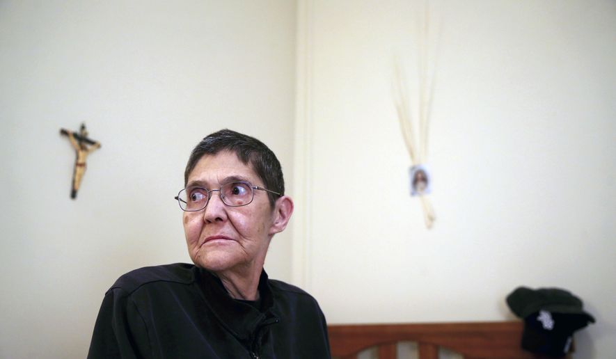 In this Wednesday, Jan. 25, 2017 photo, Marsha Wetzel poses for a photo in her room at Glen Saint Andrew Living Community in Niles, Ill. A court has heard oral arguments in a Marsha Wetzel's potentially landmark case alleging a Chicago-area senior living center did nothing to stop residents from hurling slurs and spitting on her because of her sexual orientation. (Chris Sweda/Chicago Tribune via AP)