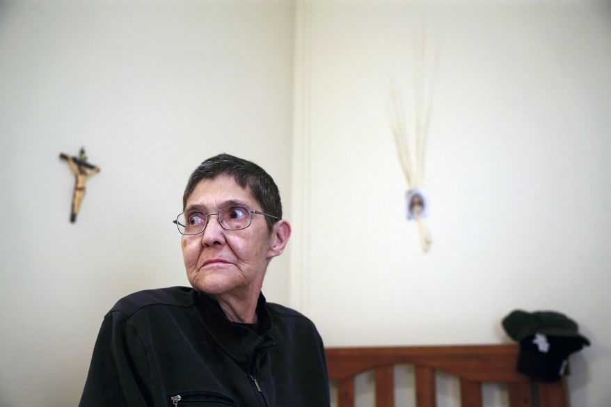 In this Wednesday, Jan. 25, 2017 photo, Marsha Wetzel poses for a photo in her room at Glen Saint Andrew Living Community in Niles, Ill. A court has heard oral arguments in a Marsha Wetzel's potentially landmark case alleging a Chicago-area senior living center did nothing to stop residents from hurling slurs and spitting on her because of her sexual orientation. (Chris Sweda/Chicago Tribune via AP)