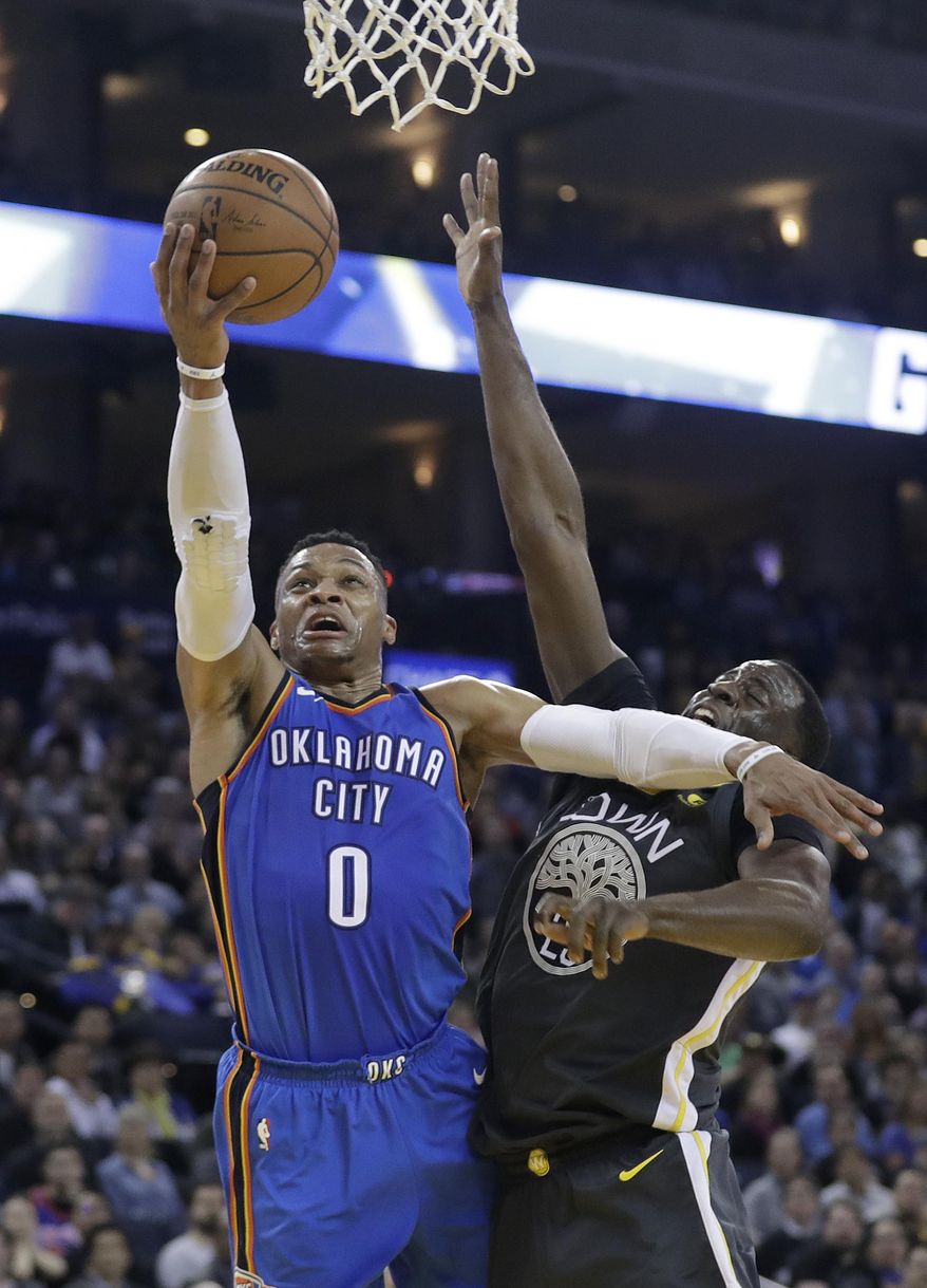 Oklahoma City Thunder&#x27;s Russell Westbrook (0) drives to the basket as Golden State Warriors&#x27; Draymond Green defends during the first half of an NBA basketball game Tuesday, Feb. 6, 2018, in Oakland, Calif. (AP Photo/Marcio Jose Sanchez)