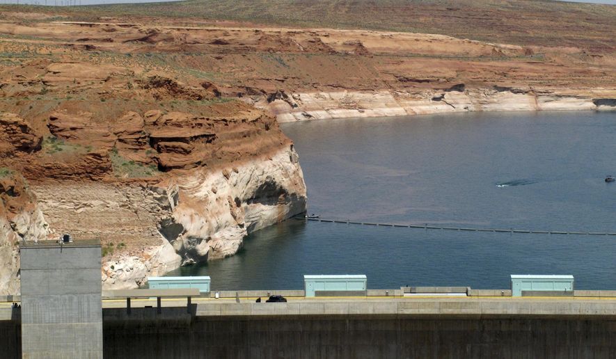 FILE - This June 21, 2015 file photo shows Lake Powell behind Glen Canyon Dam near Page, Ariz. Forecasters say one of the most important reservoirs in the Southwestern U.S. will likely collect less than half its normal amount of spring runoff this year because of a warm, dry winter across much of the region. (AP Photo/Felicia Fonseca, File)