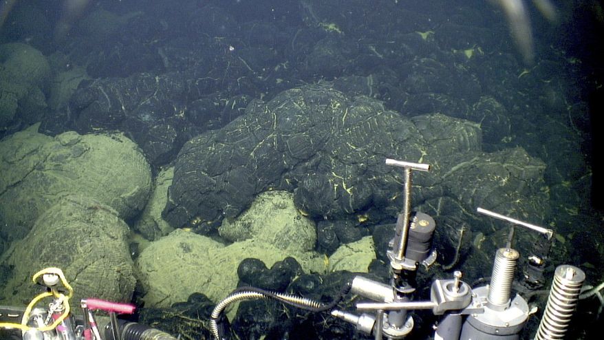 This 2015 image provided by the Woods Hole Oceanographic Institution shows the edge of the 2015 lava flow, above, at the Axial Seamount where it overlies older sedimented lavas, bottom. A study in the Wednesday, Feb. 7, 2018 journal Science Advances figures sometime after the asteroid crash creating the Chicxulub crater in the Yucatan 66 million years ago, unusual and extra strong eruptions happened on the floor of the oceans, probably the Pacific and Indian oceans. (Bill Chadwick/Oregon State University, ROV Jason, Woods Hole Oceanographic Institution via AP)