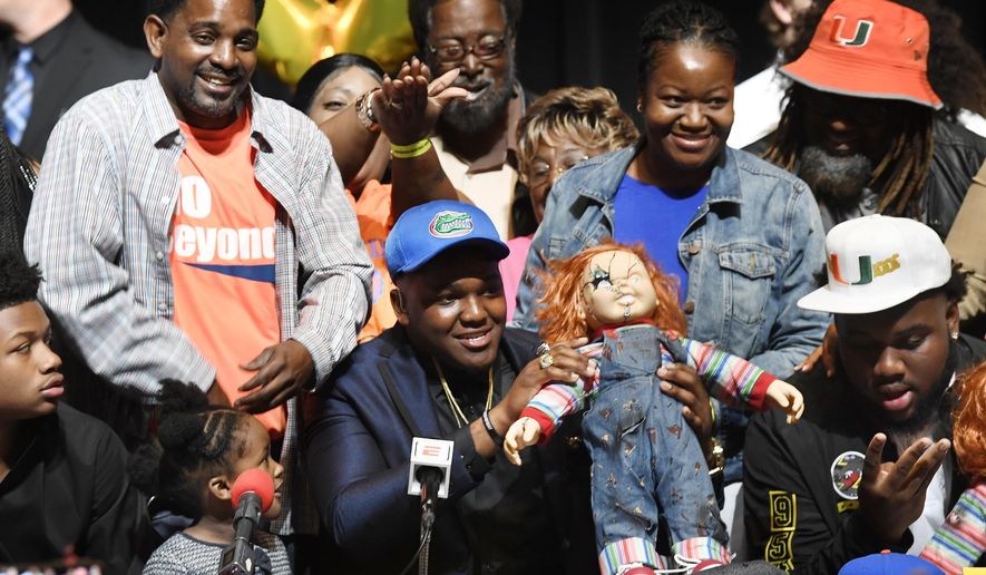 Andrew Chatfield, center, announces he's signing with the University of Florida on national signing day, Wednesday, Feb. 7, 2018, in Plantation, Fla. (Taimy Alvarez/South Florida Sun-Sentinel via AP)