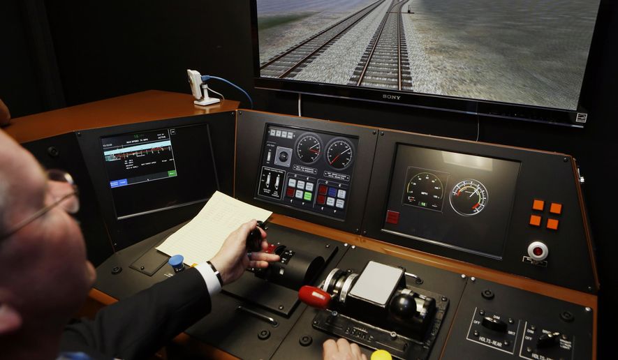 In a Feb. 20, 2014, file photo, Metrolink Director of Operations, R.T. McCarthy, demonstrates Metrolink&#39;s implementation of Positive Train Control, (PTC) at the Metrolink Locomotive and Cab Car Simulators training facility in Los Angeles&#39; Union Station. The railroad industry is downplaying expectations that a safety technology that could have prevented recent deadly train crashes will be in operation across the country by the end of the year. Officials at rail industry trade associations now say they view Dec. 31, 2018, as the date by which railroads must qualify for an extension of as much as two more years, not the ultimate deadline. (AP Photo/Damian Dovarganes, File)