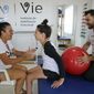 In this Feb. 1, 2018 photo, Brazil&#39;s Lais Souza attends a physiotherapy session, accompanied by her mother Odete Souza, left, in Ribeirao Preto, Brazil. The 29-year-old former Brazilian gymnast found herself paralyzed from the neck down after hitting a tree head on, during a freestyle ski practice in Utah for the 2014 Winter Olympics. (AP Photo/Andre Penner)