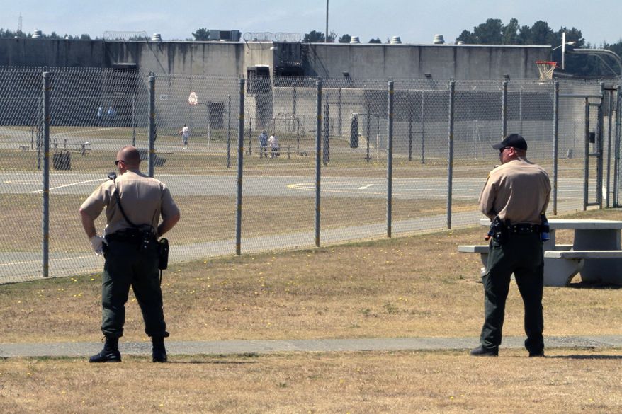 FILE - In this Aug. 17, 2011 file photo, correctional officers keep watch on inmates in the recreation yard at Pelican Bay State Prison near Crescent City, Calif. A state judge says California must consider earlier parole for potentially thousands of sex offenders, maybe even those convicted of pimping children. Sacramento County Superior Court Judge Allen Sumner preliminarily ordered prison officials to rewrite part of the regulations for Proposition 57. (AP Photo/Rich Pedroncelli, File)