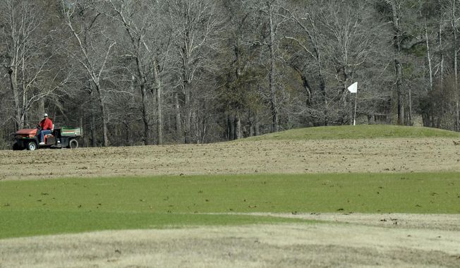 In this Tuesday, Jan. 30, 2018 photo, a groundsman drives a cart at Idylwild Golf Club in Sour Lake, Texas. The Beaumont Enterprise reports the course at Idylwild Golf Club, which Ronnie Pfleider co-owns, was left in shambles after Tropical Storm Harvey. The storm destroyed equipment, mangled bridges and cut off areas of the course. (Guiseppe Barranco/The Beaumont Enterprise via AP)