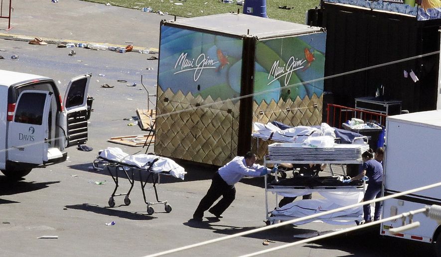 FILE - In this Oct. 2, 2017, file photo, investigators load bodies from the scene of a mass shooting at a music festival near the Mandalay Bay resort and casino on the Las Vegas Strip in Las Vegas. An autopsy found Las Vegas shooter Stephen Paddock had anti-anxiety drugs in his system but was not under the influence of them and was otherwise healthy.  A Las Vegas judge has ordered The Associated Press and Las Vegas Review-Journal to return copies of a redacted autopsy of an off-duty police officer killed in the deadliest mass shooting in modern U.S. history, Friday, Feb. 9, 2018. (AP Photo/Chris Carlson, file)