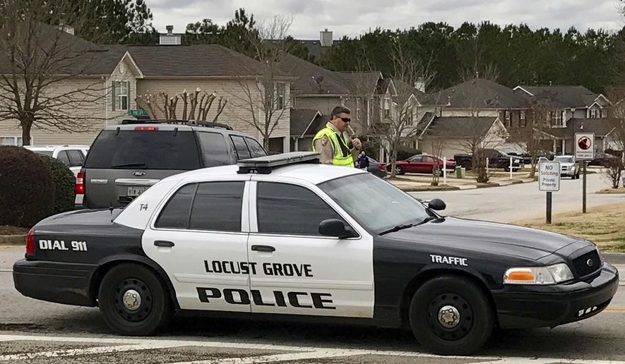 Authorities investigate the scene where multiple law enforcement officers have been shot and a suspect is dead south of Atlanta, Friday, Feb. 9, 2018, in Locust Grove, Ga. WSB-TV, citing the Henry County Sheriff's Office, reports that two local sheriff's deputies and a Locust Grove officer were shot. The sheriff says the man who shot them is dead. (AP Photo/Jeff Martin)