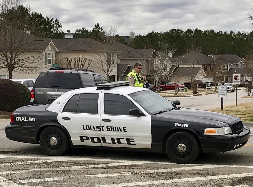 Authorities investigate the scene where multiple law enforcement officers have been shot and a suspect is dead south of Atlanta, Friday, Feb. 9, 2018, in Locust Grove, Ga. WSB-TV, citing the Henry County Sheriff's Office, reports that two local sheriff's deputies and a Locust Grove officer were shot. The sheriff says the man who shot them is dead. (AP Photo/Jeff Martin)